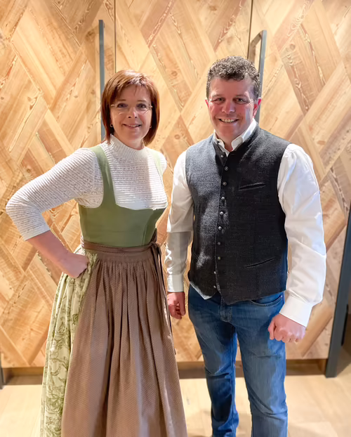 Andrea und Michael Wimpissinger - Gastgeber im Hotel Platzlhof Andrea und Michael stehen vor dem vertäfelten Schrank in einer Suite im Hotel Platzlhof
